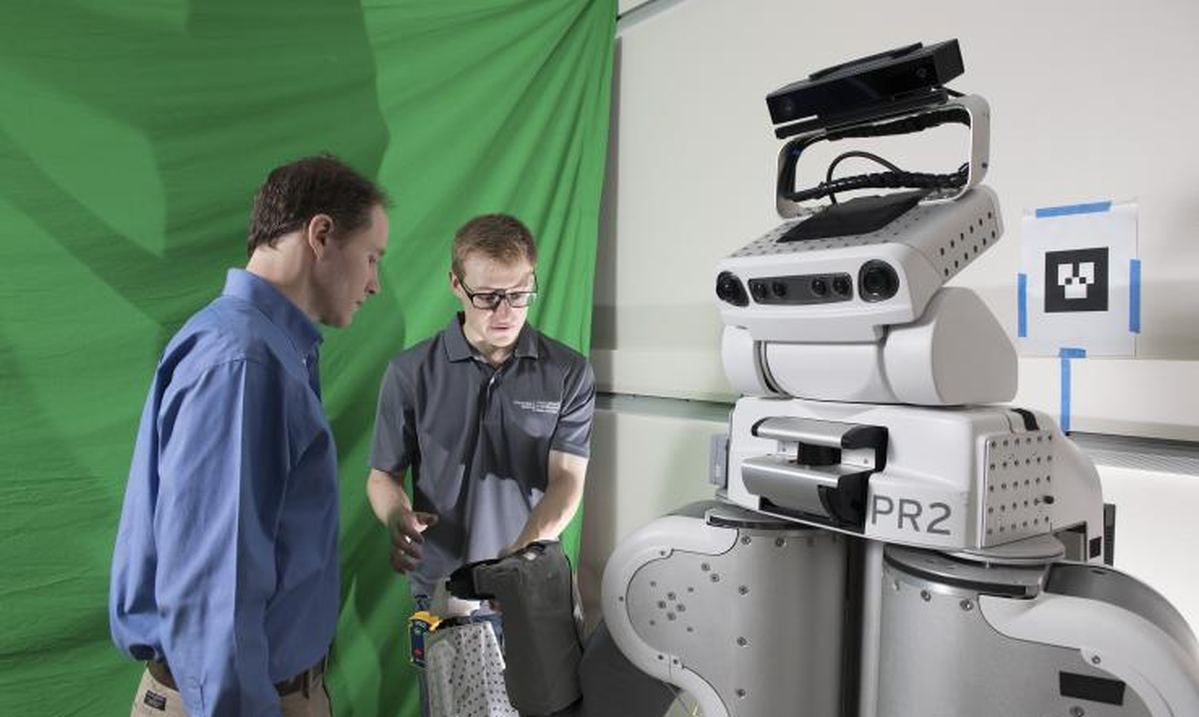 Charlie Kemp and student with the PR2 Robot