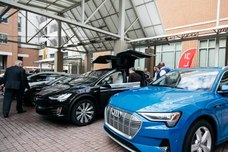 Several EV models are displayed at an electric transportation conference.