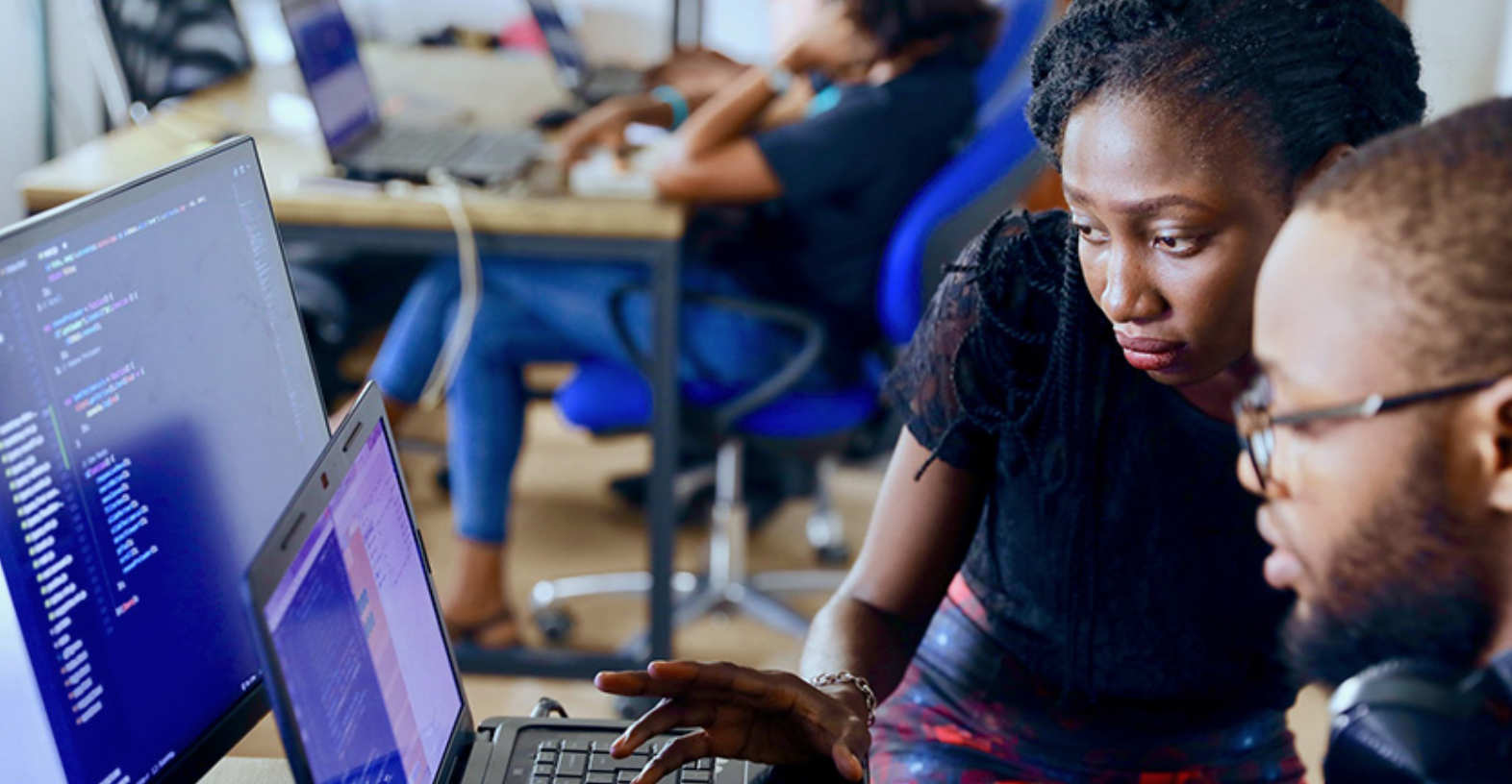 manager showing associate something on computer