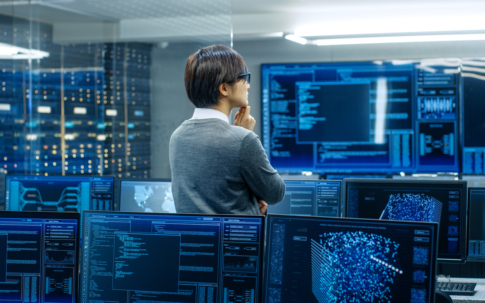 man standing in a room filled with computers and screens