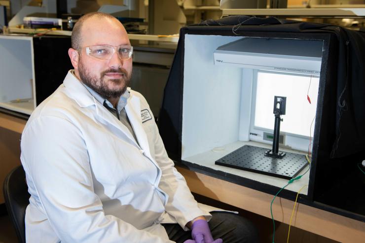 <p>Graduate Research Assistant Dylan Christiansen is shown with a transparent electrochemical cell that allows examination of materials color change upon application of an oxidizing voltage. (Photo: Allison Carter, Georgia Tech)</p>