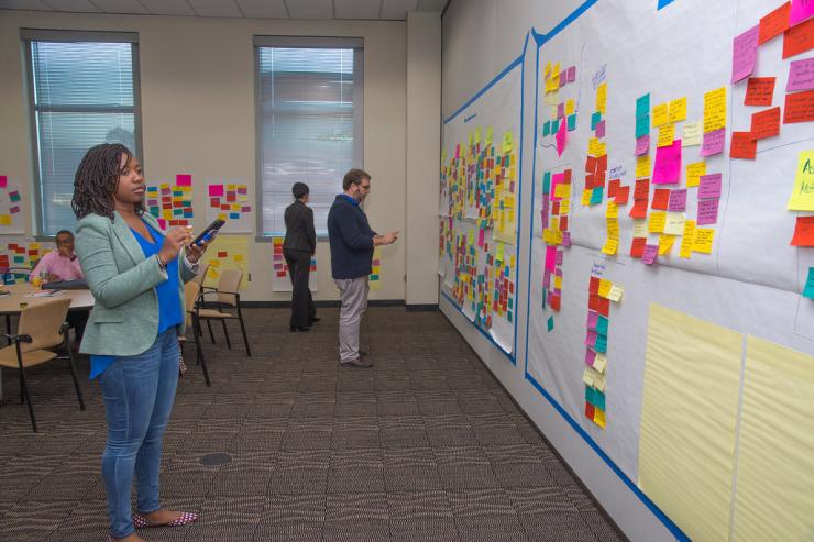 <p>Participants at the Negotiating the Digital and Data Divide Workshop cluster ideas into topics. Kari Jordan, Director of Assessment at Data Carpentry; Nicholas Horton, Professor of Statistics at Amherst College; (seated) Melvin Greer, Chief Data Scientist at Intel Corp.</p>