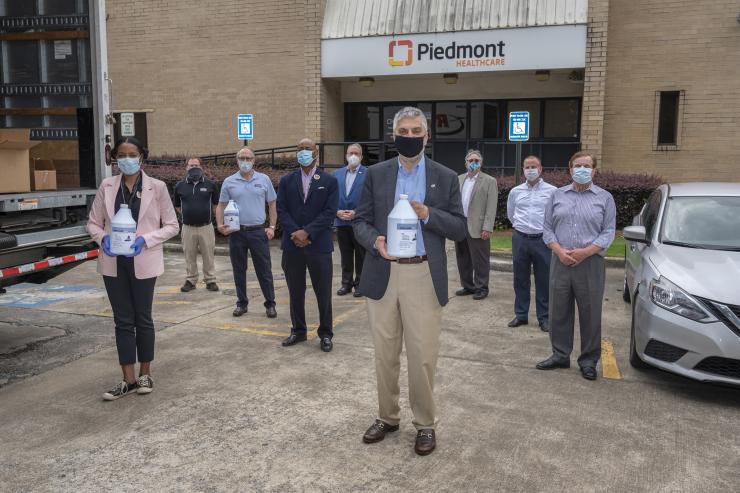 <p>Here, many participants in the effort that re-made hand sanitizer using fuel-grade ethanol on its first day of delivery. The volunteers will donate 7,000 gallons of Han-I-Size White and Gold to hospitals and nursing homes across the country. In front, Dr. Chaouki Abdallah, Executive Vice President for Research, congratulates the group on its success. </p>