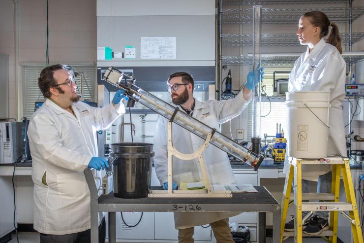 <p>An auger test cell is being used by Georgia Tech Research Institute researchers to evaluate different techniques for moving and processing waste as part of the “Reinventing the Toilet” project. Shown are Michael Jeffries, research technologist; Liam Renaghan, senior research engineer and Kristine Sherman, research engineer. (Photo: Branden Camp, Georgia Tech).</p>