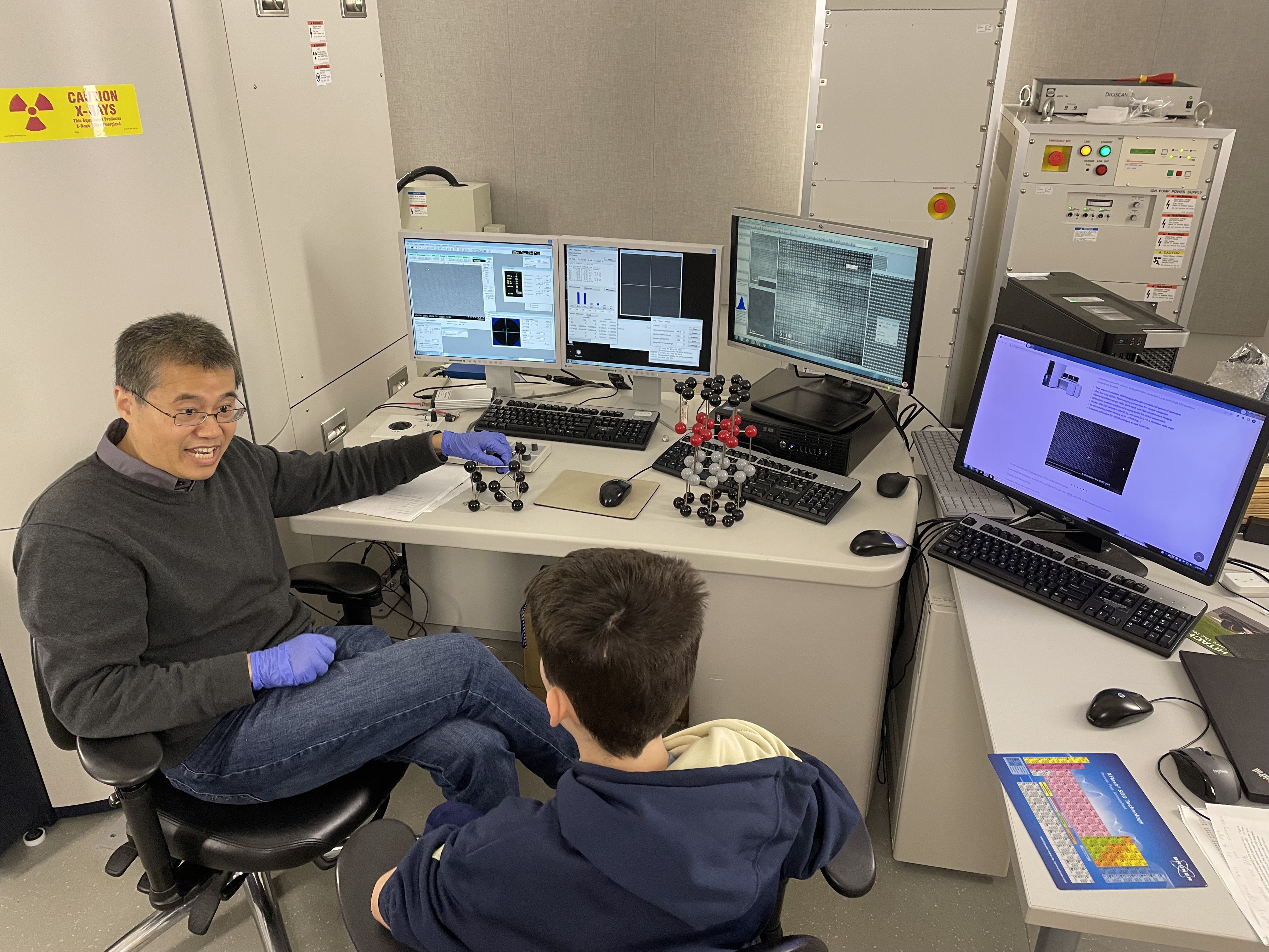 Yong Ding, principal research engineer, teaching a young student about microscopy.