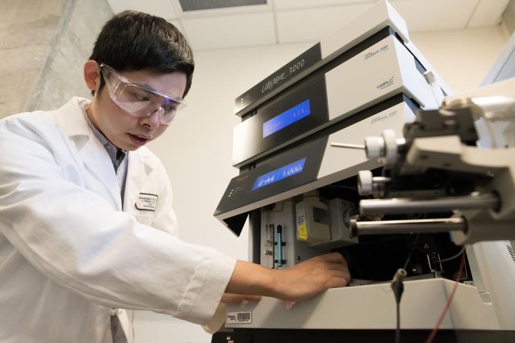 Haopeng Xiao loads mass spectrometer in Wu lab