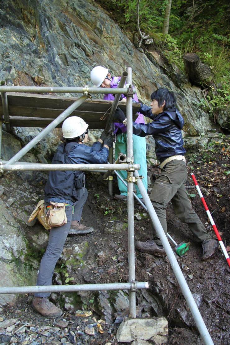 <p>First author Kazumi Ozaki (r.) takes geological samples from layers of rock formed during the Great Permian Extinction. He is shown here with other researchers in Japan doing work unrelated to this study.  Credit: Satoshi Takahashi / University of Tokyo</p>