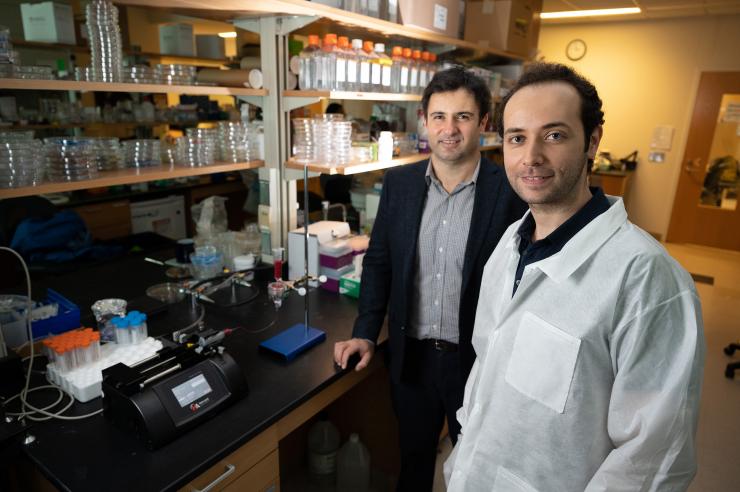 <p>Prof. A. Fatih Sarioglu (left) and the graduate student Mert Boya are near the instrumental setup used to process the patient blood samples.</p>