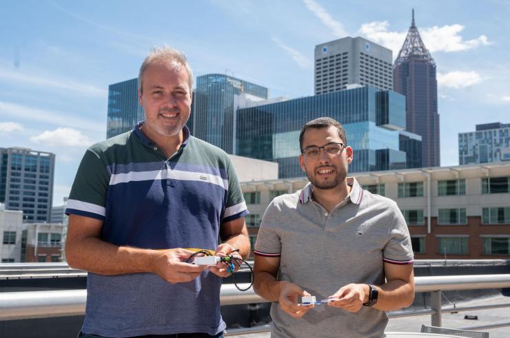 <p>Samer Mabrouk and Omer Inan hold prototypes of their device.</p>