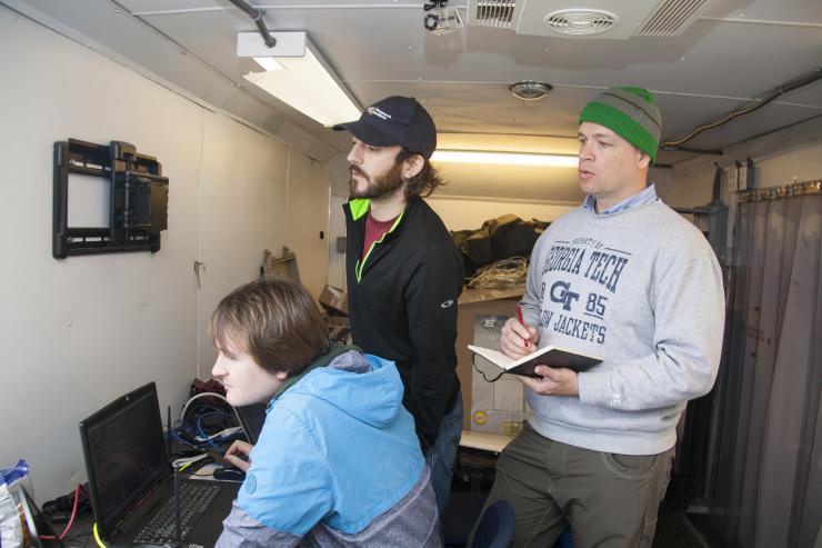 <p>Georgia Tech Research Institute team members (l-r) David Jensen, Kevin DeMarco and Charles Pippin are shown preparing for a demonstration between two swarms of unmanned air vehicles. (U.S. Navy photo by Javier Chagoya)</p>