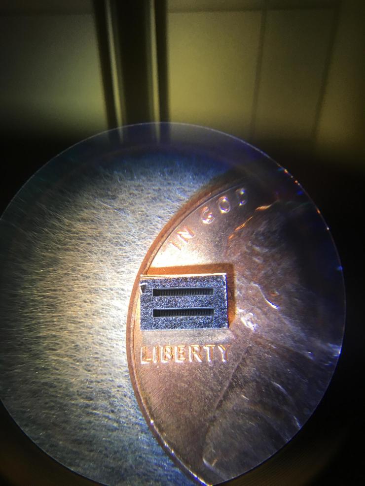 <p>The collimator sized up on a penny with a view from above. The gaps seen here are the spaces separating the three phases of the exactly aligned collimator cascade. Credit: Credit: Georgia Tech / Chao Li</p>