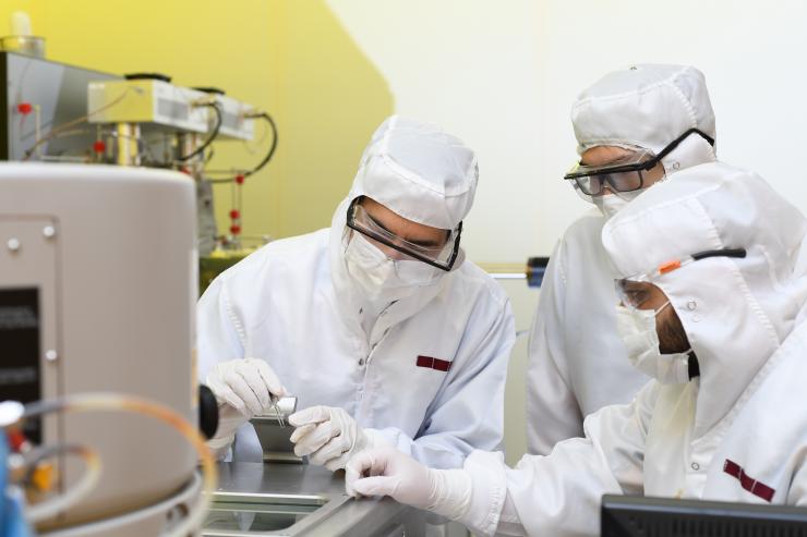 <p>Three researchers in the study point at the collimator at the end of tweezers. Credit: Georgia Tech / Christopher Moore</p>