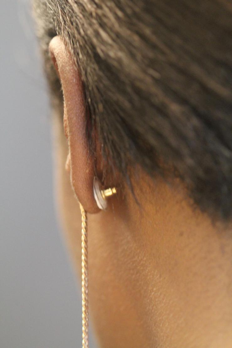 <p>A contraceptive earring patch is shown as it would be worn on a woman’s ear. The white contraceptive patch can be seen attached to the earring back and adhered to the back of the ear. (Credit: Mark Prausnitz, Georgia Tech)</p>