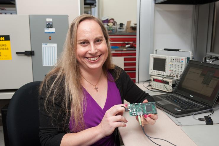 <p>Georgia Tech Professor Jennifer Hasler holding one of the FPAA devices. (Credit: Fitrah Hamid, Georgia Tech)</p>