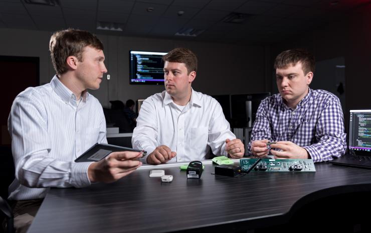 <p>GTRI researchers (l-r) Heyward Adams, Andrew Hardin and Greg Bishop examine Internet of Things devices whose output can be integrated using GTRI’s new FUSE software. (Credit: Rob Felt, Georgia Tech)</p>