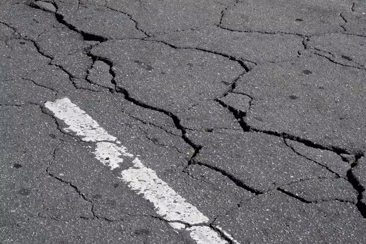 Streets crack under heat because higher temperatures create more space between vibrating molecules, causing the material to expand and deform. Priscila Zambotto/Moment via Getty Images