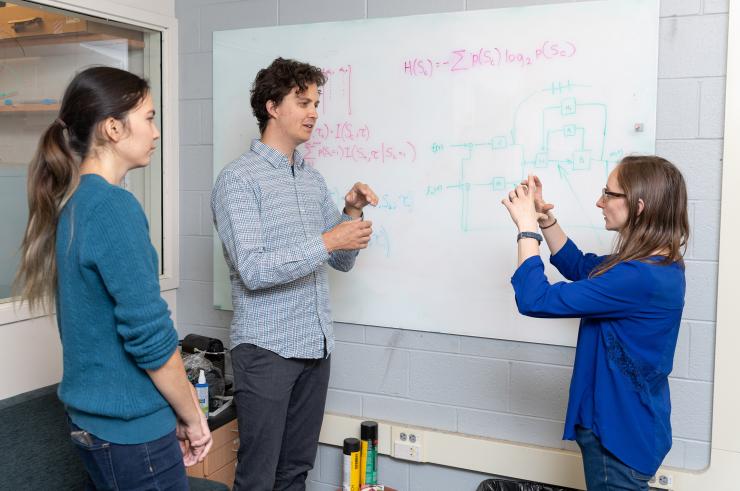 <p>Researchers Joy Putney, Simon Sponberg, and Rachel Conn discuss analysis of signals from a hawk moth (<em>Manduca sexta</em>). The research showed that millisecond changes in timing of the action potential spikes conveys the majority of information the moth uses to coordinate the muscles in its wings. (Credit: Rob Felt, Georgia Tech)</p>