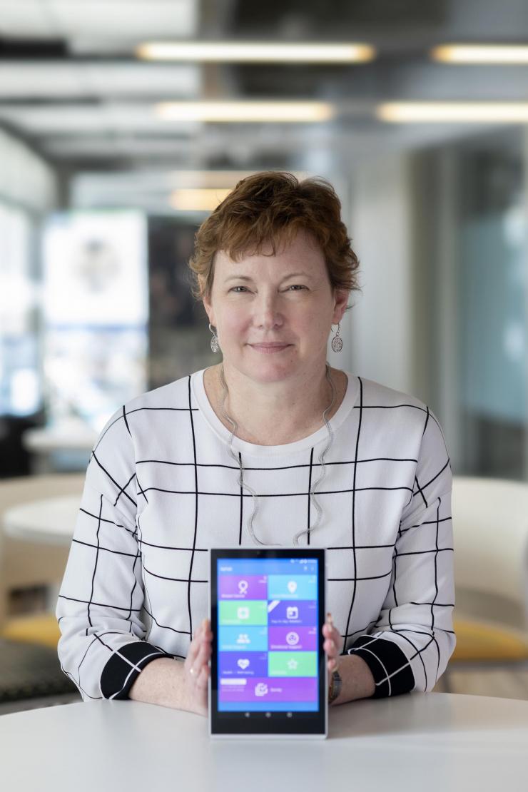 <p>Elizabeth Mynatt, executive director of the Georgia Tech Institute for People and Technology and a professor in the Georgia Tech School of Interactive Computing, holds a tablet computer running the MyPath application. (Photo: Christopher Moore, Georgia Tech)</p>