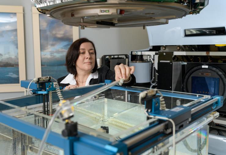 <p>Georgia Tech Associate Professor Anna Erickson positioning a new radiation detector prototype in the Varian Clinac beam to study radiation damage. (Photo: Rob Felt, Georgia Tech)</p>