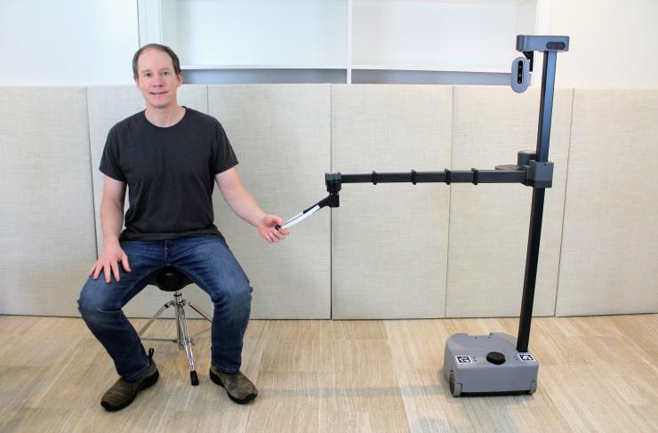 Georgia Tech robotics expert Charlie Kemp poses with his robot Stretch RE1 from Hello Robot, Inc. Robots like Stretch REI will be used in the TRI research to improve how people and robots work together. (Photo credit: Charlie Kemp, Georgia Tech)