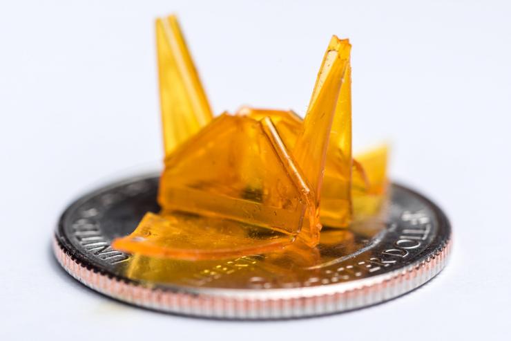 <p>A tiny origami structure created through a self-folding process is shown on a quarter for size comparison. (Credit: Rob Felt, Georgia Tech)</p>