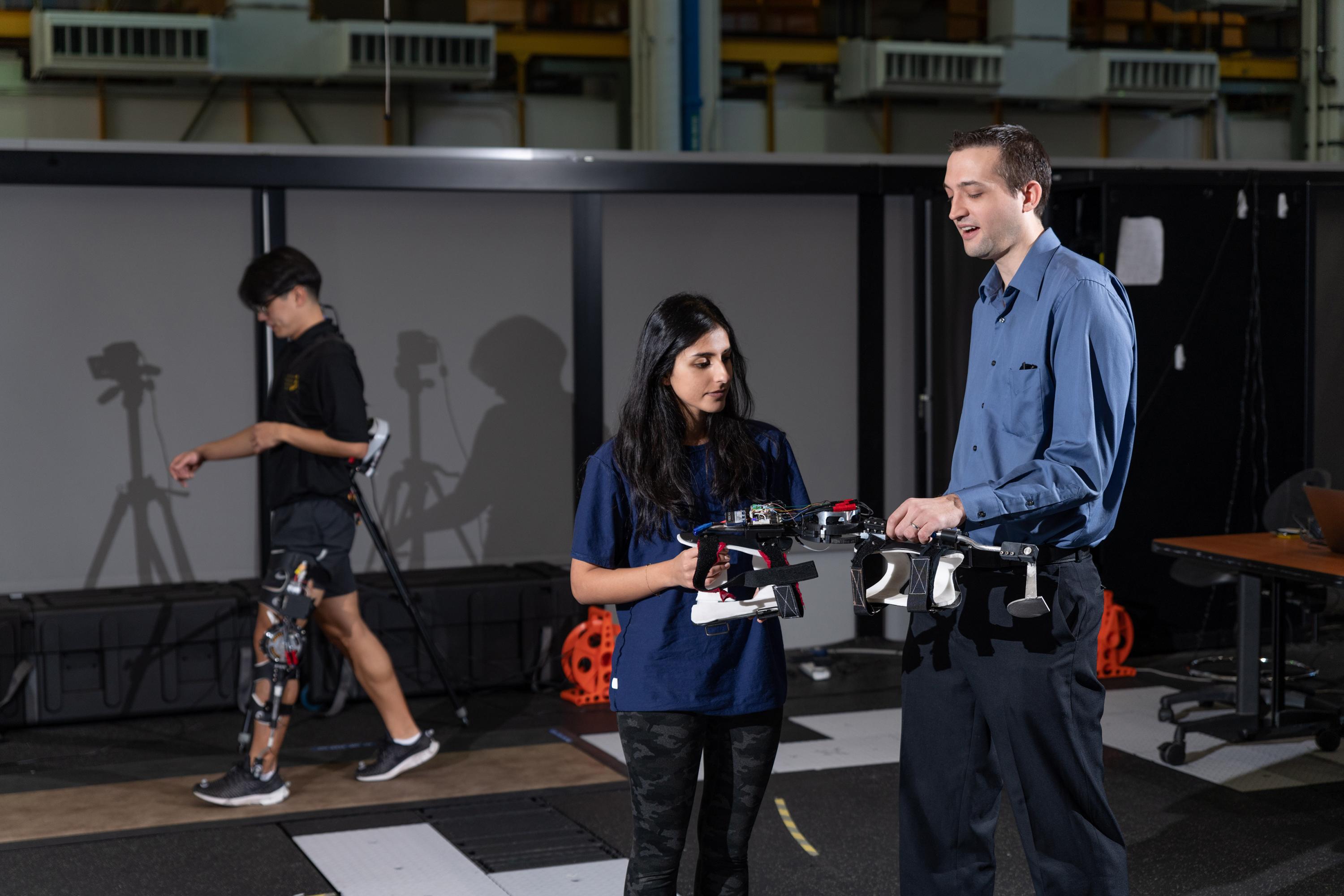 Aaron Young, Georgia Tech assistant professor of mechanical engineering, and graduate researcher Pooja Moolchandani inspect one of the pediatric knee exoskeletons developed in the EPIC Lab. (Credit: Rob Felt, Georgia Tech)