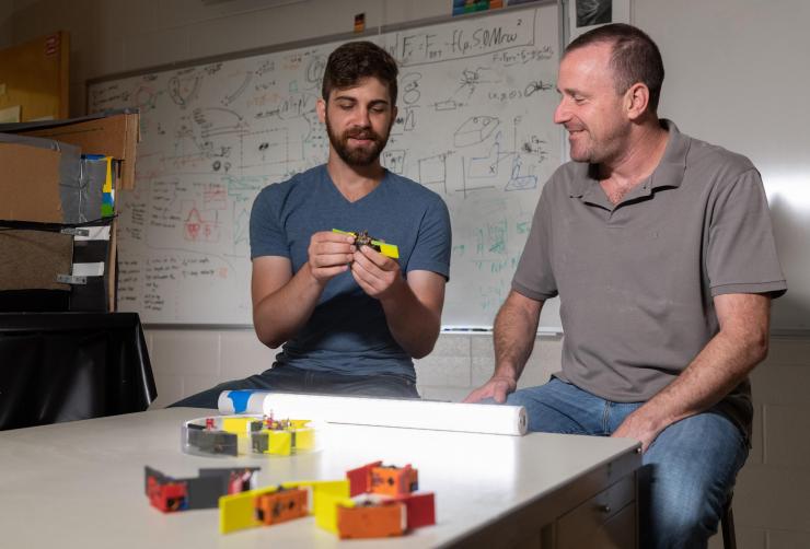 <p>Graduate research assistant Will Savoie and Associate Professor Dan Goldman examine the features of a smarticle, a term describing smart active particles. (Georgia Tech Photo: Rob Felt)</p>