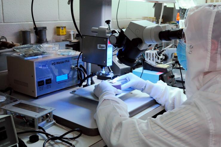 <p>GTRI researcher Hunter Chan is shown wire bonding photovoltaic cell to a package for a study of new photovoltaic materials on the International Space Station. (Credit: Gary Meek, Georgia Tech)</p>