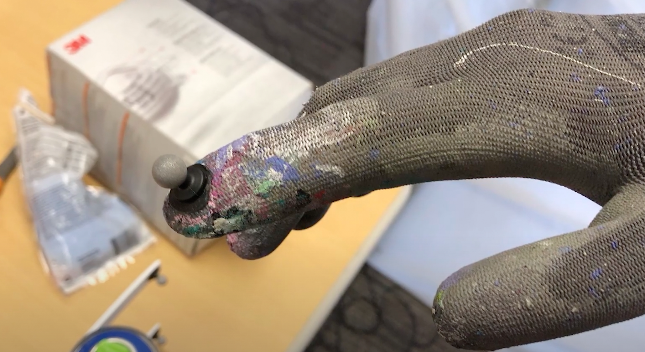 An artist's hand movements are captured with fingertip sensors. 