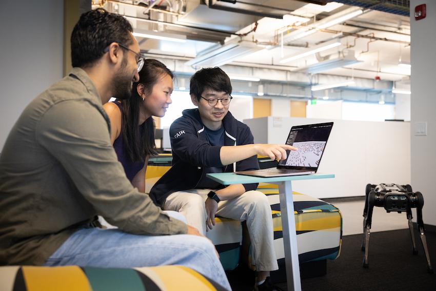 From left to right, Simar Kareer, Joanne Truong, and Naoki Yokoyam work together on developing a quadrupedal robot that can navigate over obstacles. (Photos by Kevin Beasley/College of Computing)