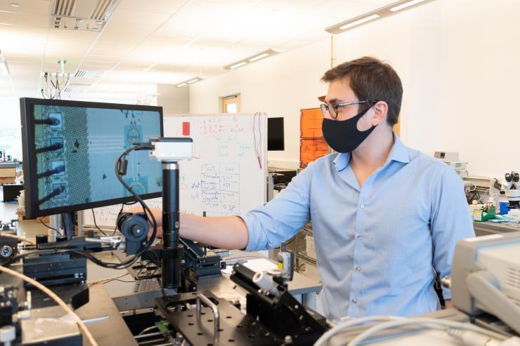 <p>Edgar Garay, a doctoral candidate at Georgia Tech's School of Electrical and Computer Engineering, reviews a set of filaments as part of a  review his microchip design for his startup, Falcomm. (Photo: Matt Hummel)</p>