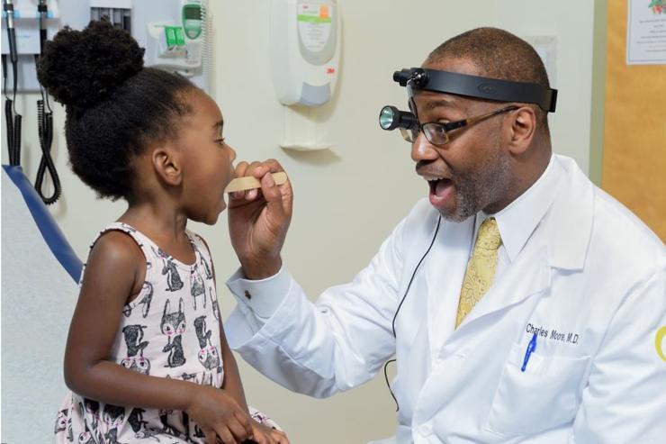 <p>Georgia CTSA investigator Charles E. Moore, MD, professor at the Emory University School of Medicine, examines a young patient.</p>