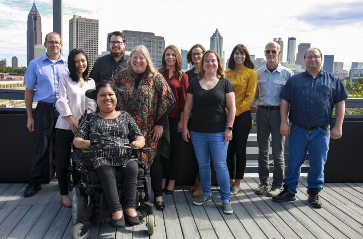 <p>Georgia Tech TechSAge team members with an Atlanta skyline view on the rooftop of 512 Means Street, home to AMAC and CATEA. Photo taken after TechSAge 2 kick-off meeting. Investigators and staff pictured here: Front row: Liz Persaud; Second row (Left to right): Su Jin (Susan) Lee, Carolyn Phillips, Maribeth Gandy Coleman, Peter Presti; Back row (Left to right): Brian Jones, Ben Jacobs, Elena Remillard, Tracy Mitzner, Sarah Melgen, Jon Sanford</p>