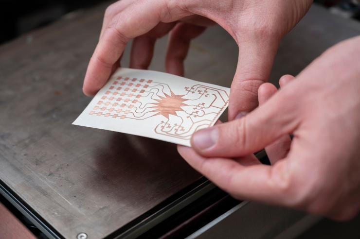 A Georgia Tech ATHENA group member holds an inkjet-printed prototype of a mm-wave harvester. The researchers envision a future where IoT devices will be powered wirelessly over 5G networks. (Photo credit: Christopher Moore, Georgia Tech)