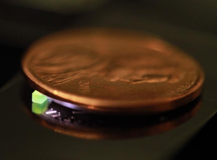 <p>A millimeter-scale structure with submicron features is supported on a U.S. penny on top of a reflective surface. (Credit: Vu Nguyen and Sourabh Saha)</p>