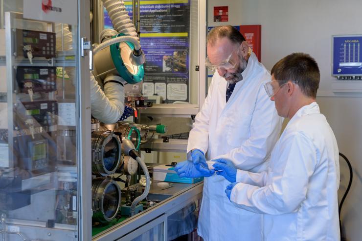 <p>Abdallah Ougazzaden, director of Georgia Tech Lorraine in Metz, France and Chris Bishop, a researcher at Institut Lafayette, example a sample being processed in a lab at Georgia Tech Lorraine. (Credit: Rob Felt, Georgia Tech).</p>