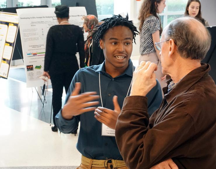 <p>Kendreze Holland, a 2019 Petit Scholar, discusses his research at a recent poster session.</p>