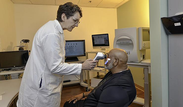 <p>Machelle Pardue performs an electroretinogram on Army Veteran Michael Brooks, who participated in her study. <em>(Photo by Joey Rodgers for VA)</em></p>