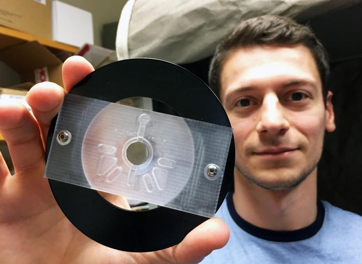 <p>Graduate research assistant Ilya Kolb shows a well structure used to hold samples (center) and detergent/rinsing solution for cleaning pipettes between recording sessions. (Credit: John Toon, Georgia Tech)</p>