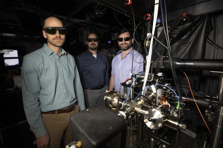 <p>GTRI researchers Creston Herold, Brian Sawyer, and Brian McMahon (l-r) shown with the compact Penning trap apparatus. (Credit: Sean McNeil, GTRI)</p>