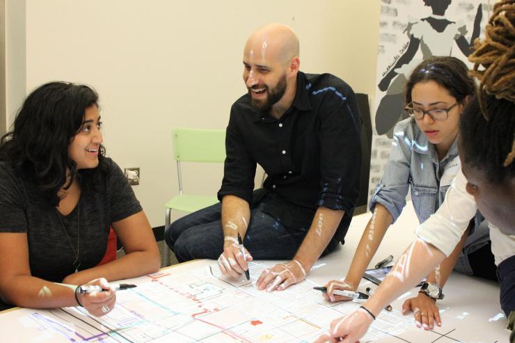 <p>Assistant Professor Yanni Loukissas talks with visitors to the Map Room in his Local Data Design Lab in the Technology Square Research Building. (Joshua Preston/GVU)</p>