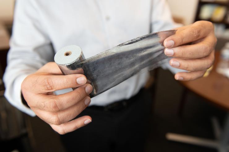 <p>Rampi Ramprasad, a professor in the School of Materials Science and Engineering, holds an aluminum-based capacitor. (Credit: Allison Carter)</p>