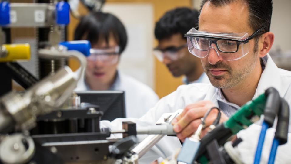 Man in lab adjusting a device