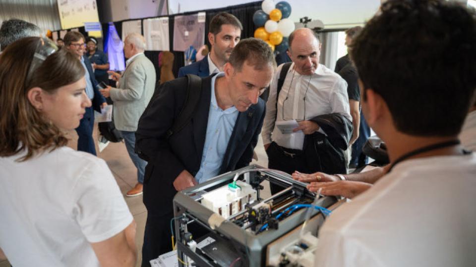 A man inspecting a device at an event